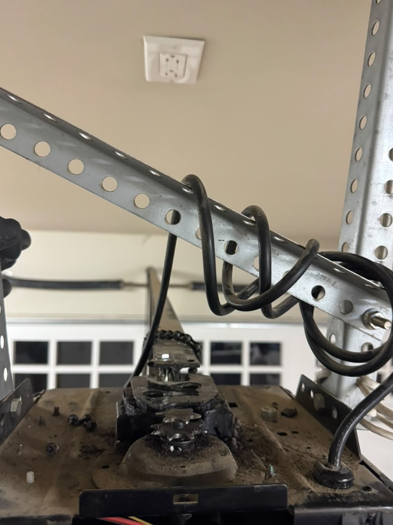 Ceiling-mounted garage door opener with chain-drive mechanism inspected during service