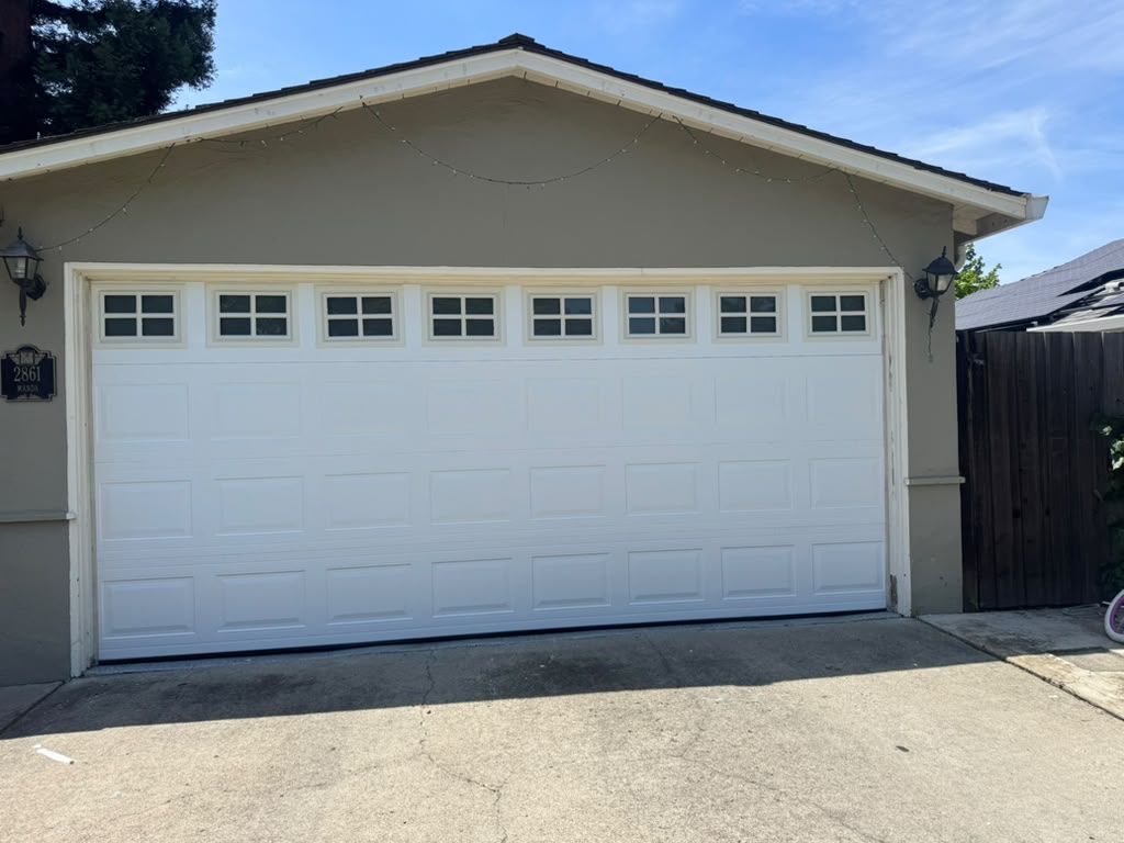 White raised-panel garage door with window row after replacement