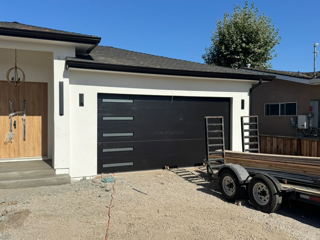 Contemporary black garage door installed on a newly built single-story home